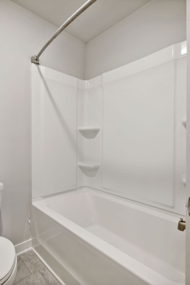 bathroom featuring tile patterned floors, tub / shower combination, and toilet