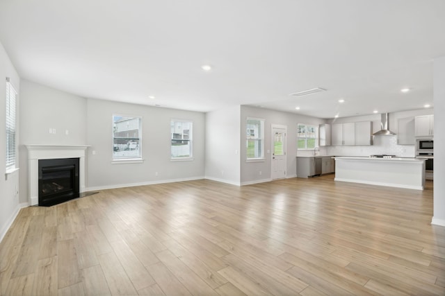 unfurnished living room featuring light hardwood / wood-style flooring and sink