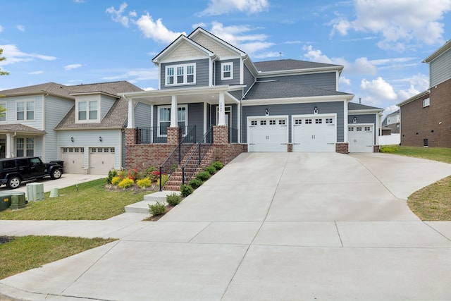 craftsman inspired home with covered porch, a front yard, and a garage