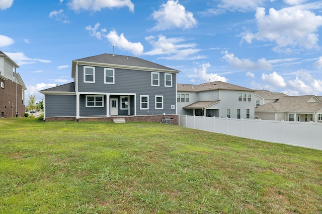 rear view of property with a lawn and central air condition unit