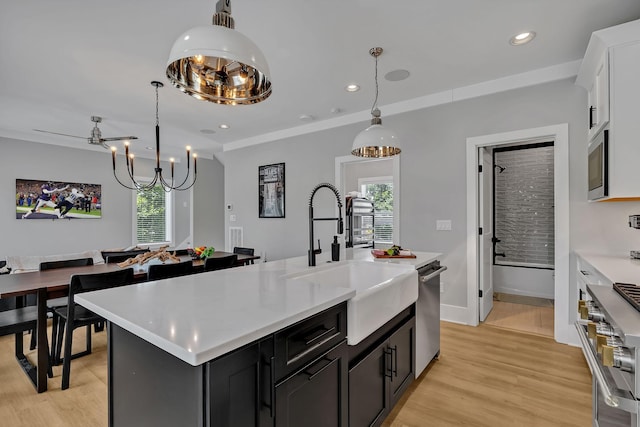 kitchen with stainless steel appliances, a sink, light countertops, and plenty of natural light