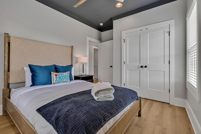 bedroom featuring light wood-style flooring, baseboards, and multiple windows