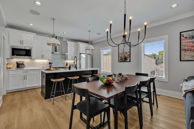 dining area featuring recessed lighting, light wood-style flooring, and ornamental molding