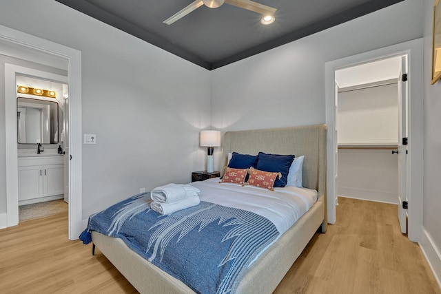 bedroom with light wood-style flooring, a ceiling fan, and a sink
