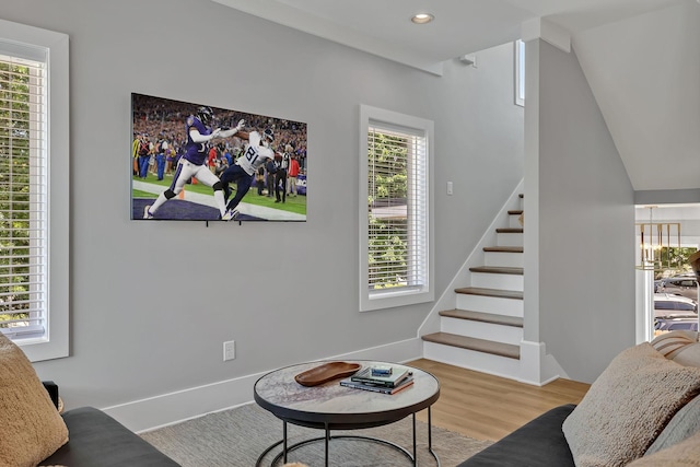 living area with baseboards, wood finished floors, recessed lighting, and stairs