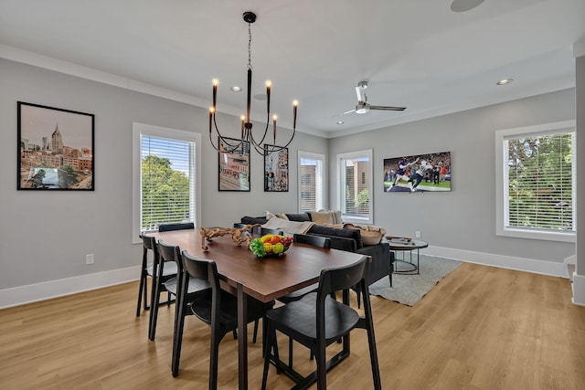 dining space with ceiling fan with notable chandelier, light wood-style flooring, baseboards, and crown molding