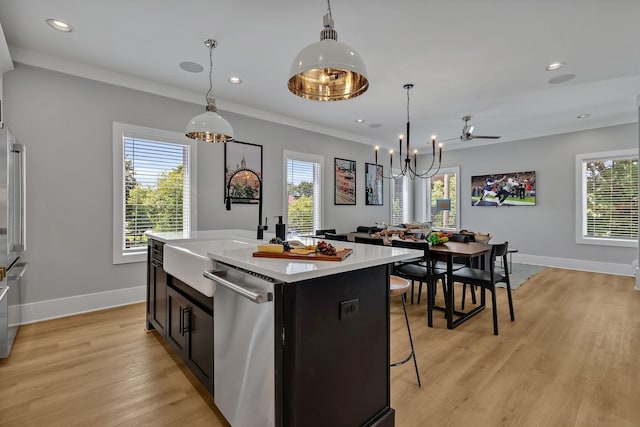 kitchen with stainless steel dishwasher, light countertops, an inviting chandelier, and a healthy amount of sunlight