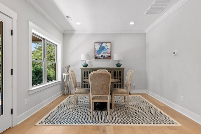 dining space with wood finished floors, visible vents, baseboards, and ornamental molding