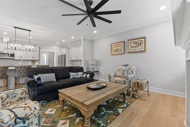 living room featuring a ceiling fan, crown molding, light wood-type flooring, baseboards, and recessed lighting