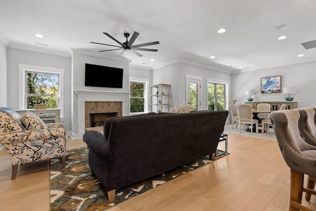 living room featuring recessed lighting, a ceiling fan, a healthy amount of sunlight, and a tiled fireplace