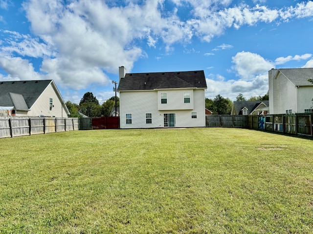 rear view of property featuring a lawn