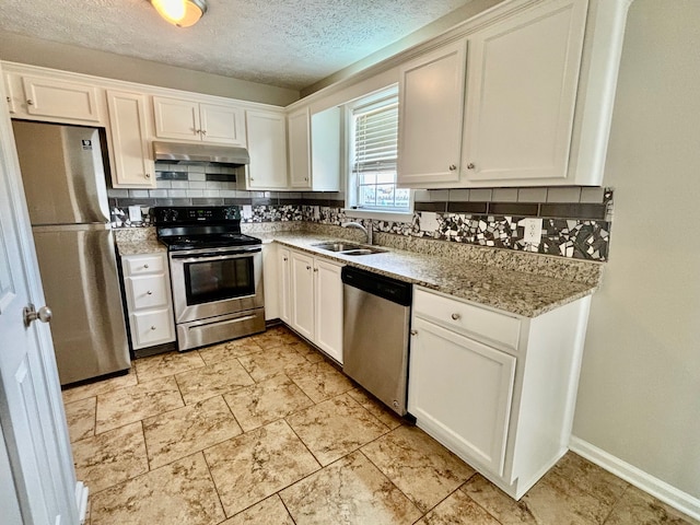 kitchen with tasteful backsplash, sink, white cabinetry, appliances with stainless steel finishes, and light stone countertops