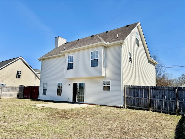 back of house with a patio area, a fenced backyard, a chimney, and a yard