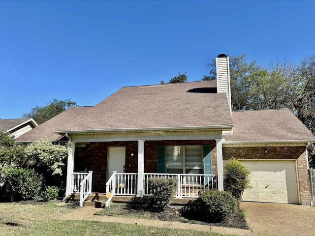 view of front of home featuring covered porch, a garage, and a front yard