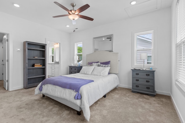 bedroom featuring ceiling fan, light colored carpet, and ensuite bathroom