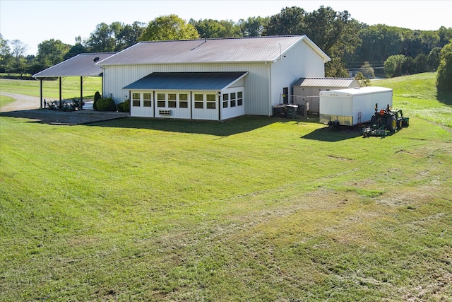 rear view of property with a sunroom and a lawn