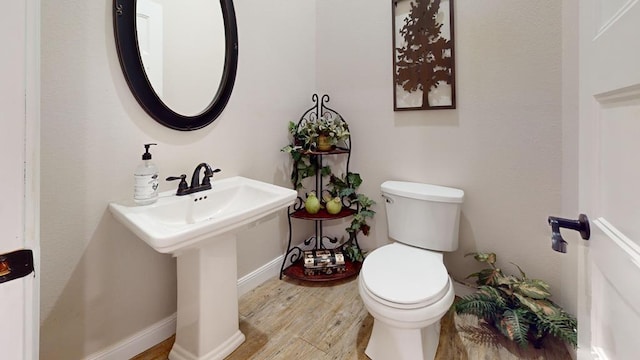 bathroom with toilet and hardwood / wood-style flooring