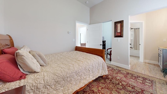 bedroom featuring hardwood / wood-style flooring and high vaulted ceiling