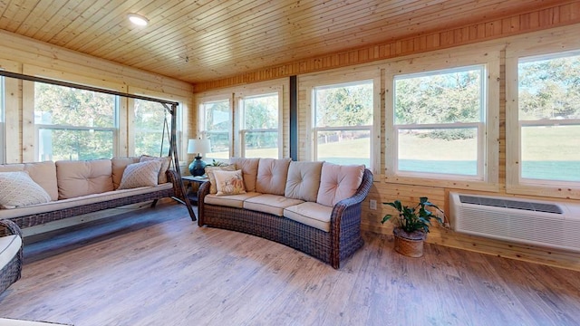 sunroom / solarium featuring a wall mounted air conditioner, a healthy amount of sunlight, and wooden ceiling