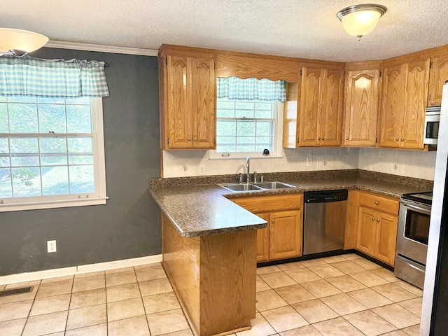 kitchen featuring light tile patterned flooring, sink, kitchen peninsula, appliances with stainless steel finishes, and crown molding