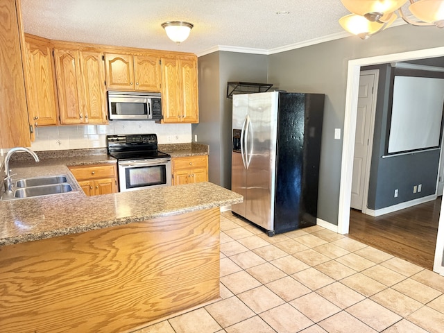 kitchen with light tile patterned floors, ornamental molding, sink, a textured ceiling, and stainless steel appliances