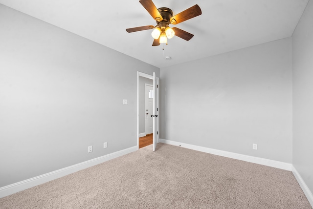 carpeted spare room with ceiling fan