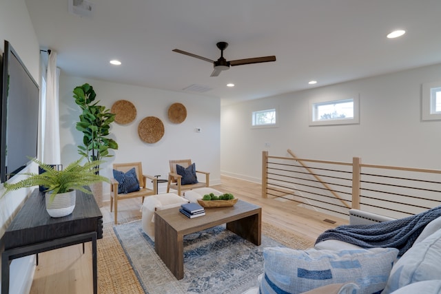 living room featuring light hardwood / wood-style flooring and ceiling fan