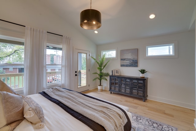 bedroom featuring hardwood / wood-style floors, multiple windows, and access to outside