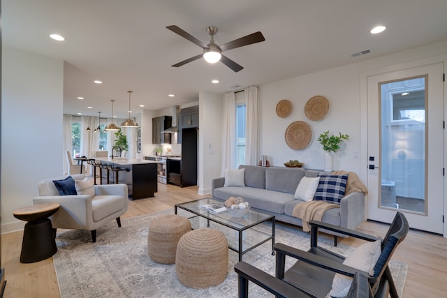 living room with ceiling fan and light wood-type flooring