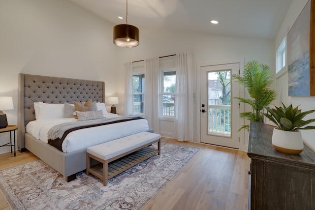 bedroom featuring light wood-type flooring, high vaulted ceiling, and access to exterior