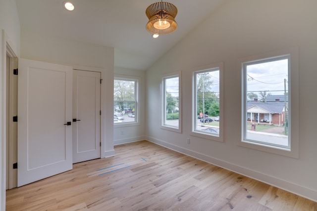 unfurnished bedroom with lofted ceiling and light hardwood / wood-style floors