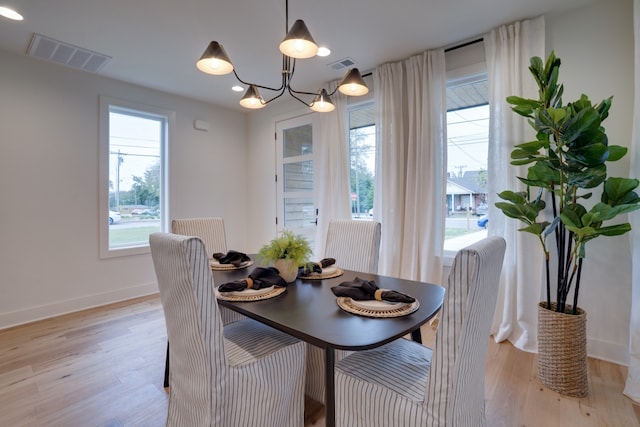 dining space featuring a notable chandelier and light hardwood / wood-style floors