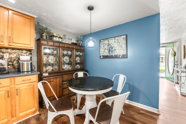 dining space with a textured ceiling and dark hardwood / wood-style flooring