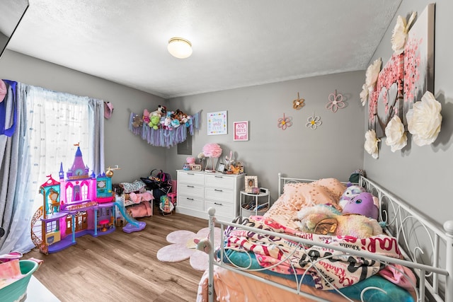 bedroom with a textured ceiling and light hardwood / wood-style flooring