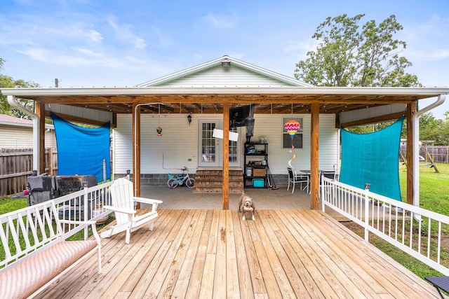 wooden deck featuring a lawn