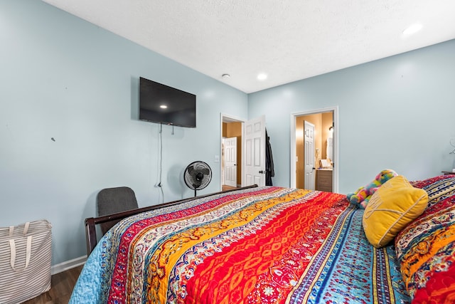 bedroom featuring a textured ceiling, connected bathroom, and dark hardwood / wood-style flooring