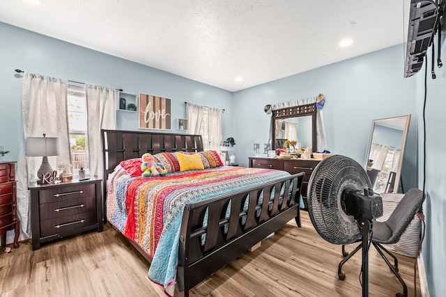 bedroom featuring light wood-type flooring and a textured ceiling