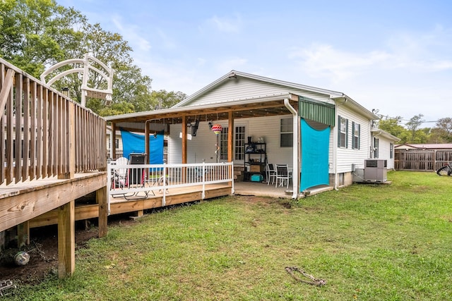 back of house featuring a deck, a yard, ceiling fan, and central air condition unit