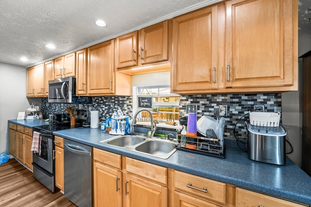 kitchen with light hardwood / wood-style flooring, stainless steel appliances, a textured ceiling, and sink