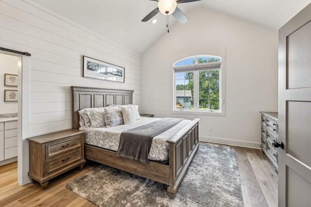 bedroom featuring light hardwood / wood-style floors, vaulted ceiling, and ceiling fan