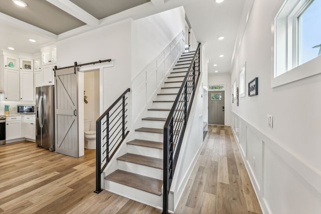 stairway with hardwood / wood-style floors and a barn door