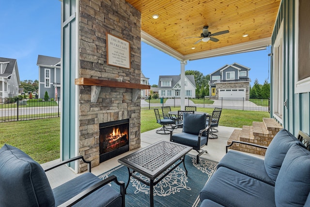 view of patio featuring ceiling fan, a garage, and an outdoor living space with a fireplace