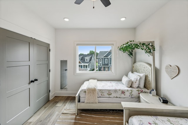 bedroom with light hardwood / wood-style flooring, a closet, and ceiling fan