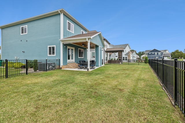 back of property with a patio, ceiling fan, and a yard