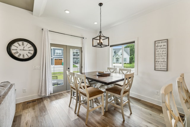 dining space featuring hardwood / wood-style flooring and a notable chandelier