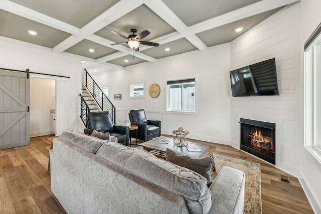 living room featuring a wealth of natural light, light hardwood / wood-style floors, and a barn door