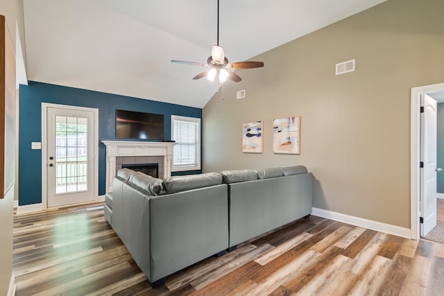 living room with high vaulted ceiling, ceiling fan, a fireplace, and hardwood / wood-style floors