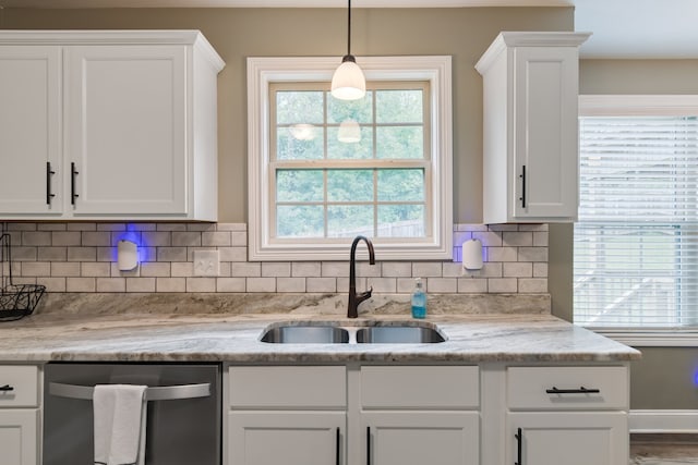 kitchen with sink, white cabinets, decorative backsplash, light stone countertops, and stainless steel dishwasher