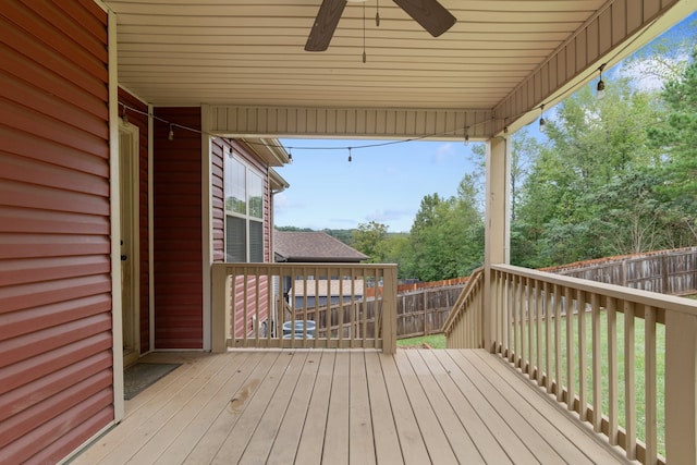 wooden terrace featuring a lawn and ceiling fan