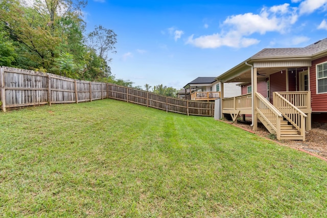 view of yard with ceiling fan and a deck